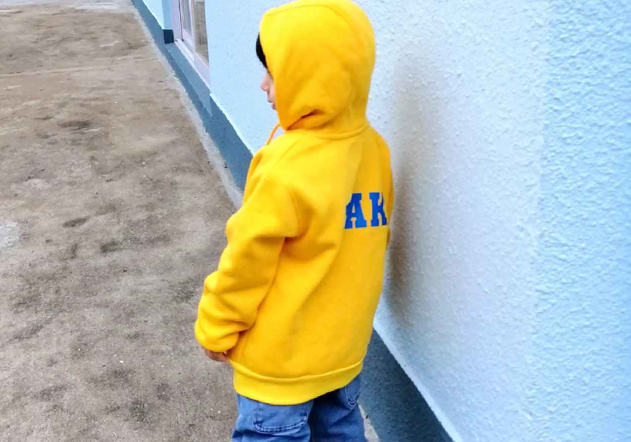 A young boy wearing a yellow personalised Groovie-Hoodie